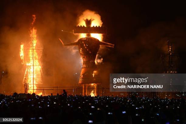 Indian Hindu devotees watch an effigy of the Hindu demon king Ravana, stuffed with firecrackers, burning in Amritsar on October 19 on the occasion of...