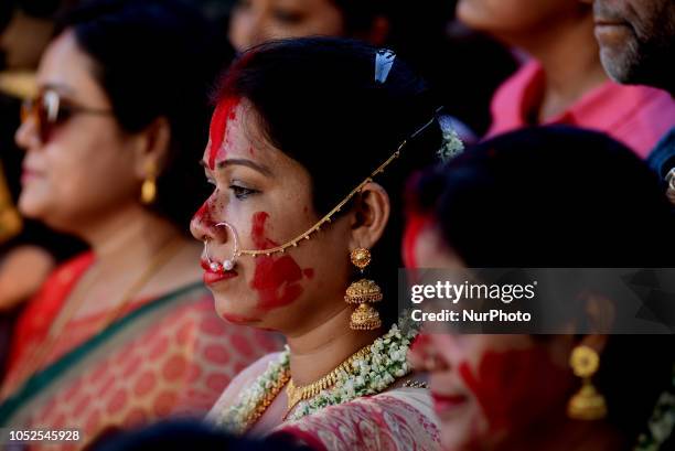 Hindu woman prays to goddess Durga while a statue of the goddess is immersed in the Ganges river during the immersion ceremony of the Durga Puja...
