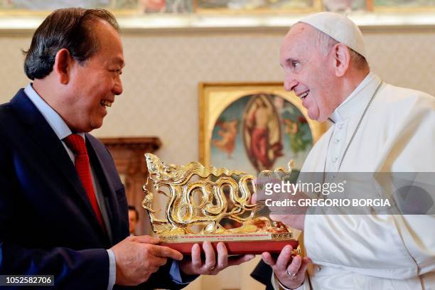 Pope Francis is presented with a gift by Vietnam Deputy Prime Minister, Truong Hoa Binh during a private audience at the Vatican on October 20, 2018.