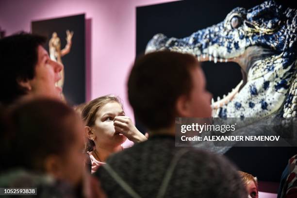 Visitors stand in front of the photograph 'Cuban Crocodile' by Tim Flach, a British photographer who specialises in studio photography of animals,...