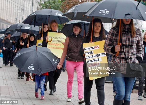 Ukrainians carry posters and black umbrellas during their silent march against of human trafficking called &quot;Walk for Freedom&quot;, in downtown...