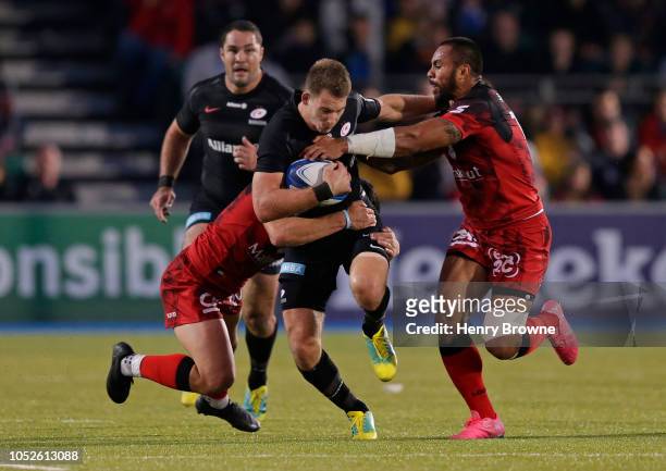 Liam Williams of Saracens is tackled by Rudi Wulf and Adrien Seguret of Lyon during the Champions Cup match between Saracens and Lyon Olympique...