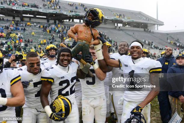 Michigan Wolverines cornerbacks Ambry Thomas and David Long celebrate with the Paul Bunyan trophy along with their teammates following a Big Ten...