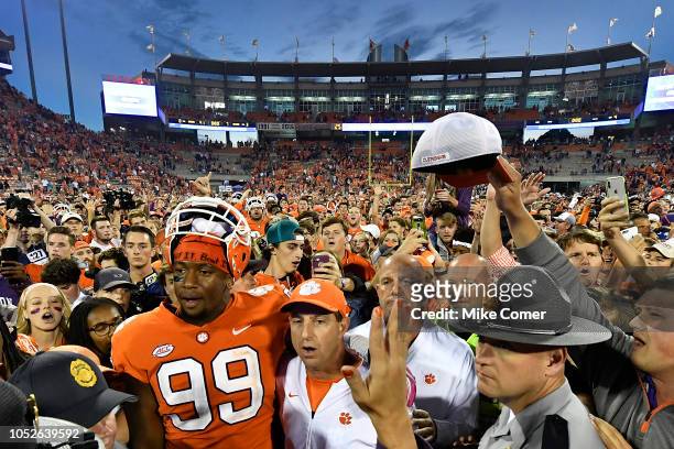 Defensive end Clelin Ferrell and head coach Dabo Swinney of the Clemson Tigers embrace at midfield while surrounded by fans singing the Clemson Alma...