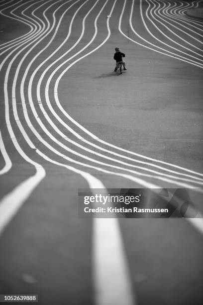 copenhagen, nørrebro, denmark - september 8, 2018: rear view of a small boy riding his bicycle in the public park superkilen. the park opened in june 22, 2012 and was designed by superflex in cooperation with bjarke ingels group and topotek1. - copenhagen park stock pictures, royalty-free photos & images