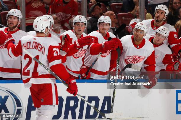 Dennis Cholowski of the Detroit Red Wings is congratulated by teammates after scoring a goal against the Florida Panthers at the BB&T Center on...