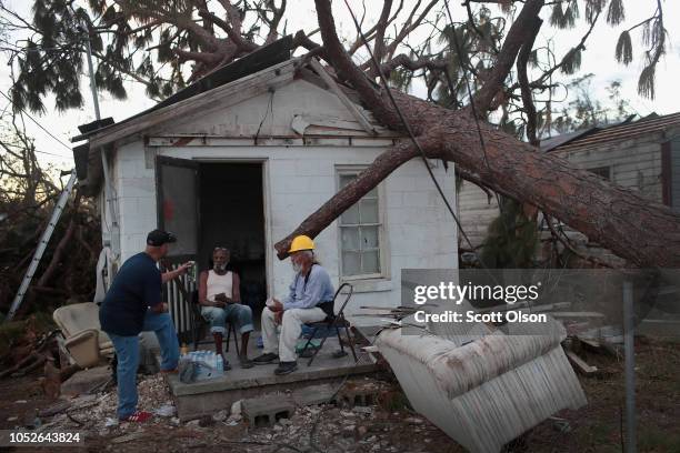 Bladimil Sanchez and his father Juan check on the well-being of a friend and neighbor Jose Herrera whose home which was severely damaged by Hurricane...