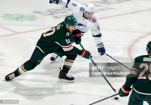 Matt Read of the Minnesota Wild skates with the puck as Tyler Johnson of the Tampa Bay Lightning defends during a game between the Minnesota Wild and...