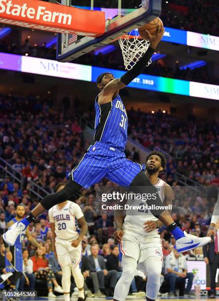 Terrence Ross of the Orlando Magic lays up a shot as Joel Embiid of the Philadelphia 76ers watches at Wells Fargo Center on October 20, 2018 in...