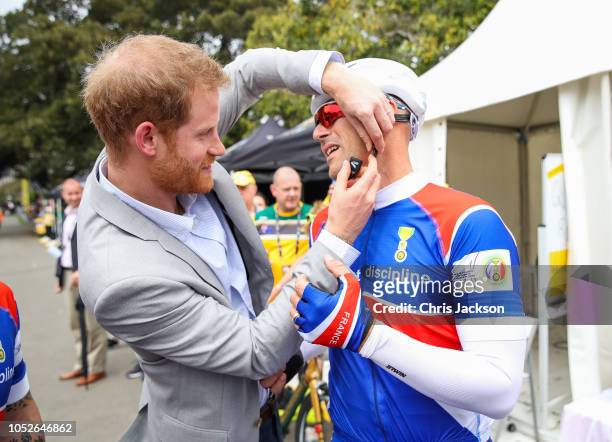 Exclusive behind the scenes of Prince Harry, Duke of Sussex helping put on helmet during day two of the Invictus Games Sydney 2018 at Sydney Olympic...