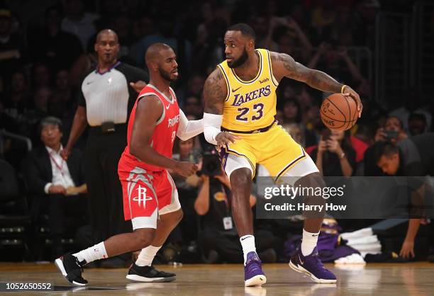 LeBron James of the Los Angeles Lakers dribbles the ball against Chris Paul of the Houston Rockets during the first quarter at Staples Center on...