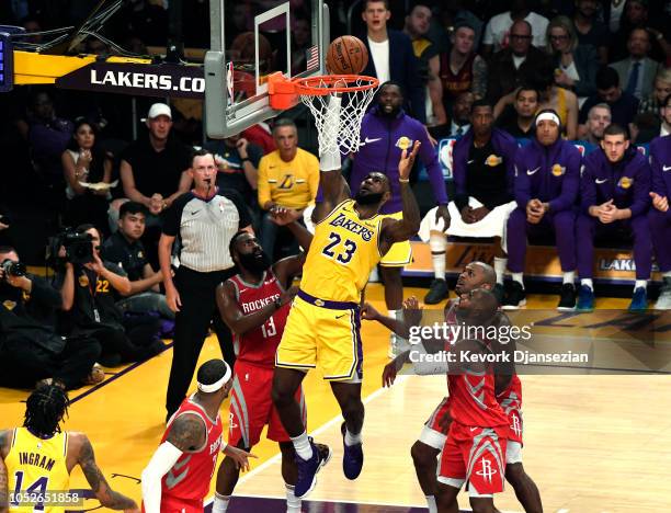LeBron James of the Los Angeles Lakers scores a basket as James Harden, Chris Paul, Carmelo Anthony and PJ Tucker of the Houston Rockets look on as...