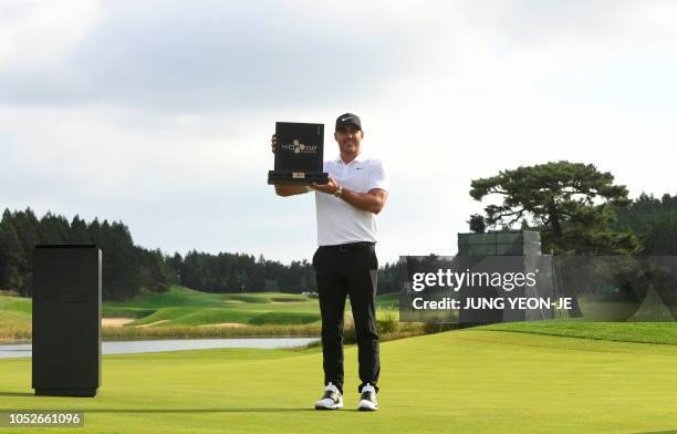 Brooks Koepka of the US poses with the trophy during the awards ceremony after winning the CJ Cup golf tournament at Nine Bridges golf club in Jeju...