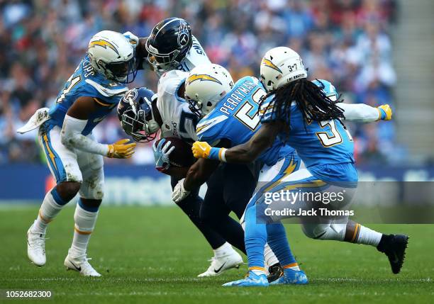 Dion Lewis of the Tennessee Titans is tackled by Denzel Perryman of the Los Angeles Chargers during the NFL International Series game between...