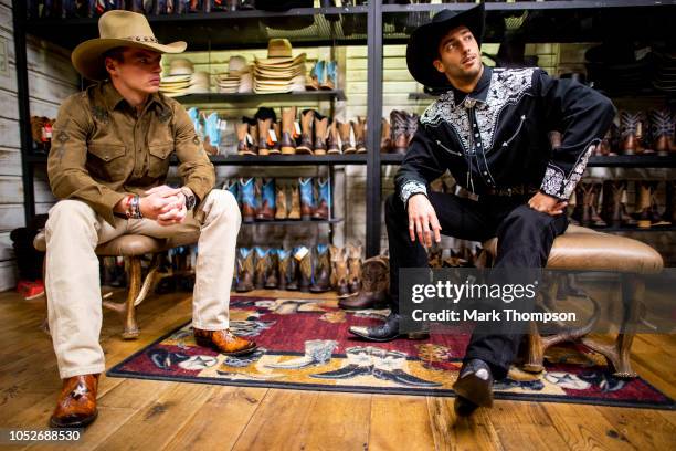 Daniel Ricciardo of Australia and Red Bull Racing and Max Verstappen of Netherlands and Red Bull Racing get dressed in traditional cowboy clothing in...
