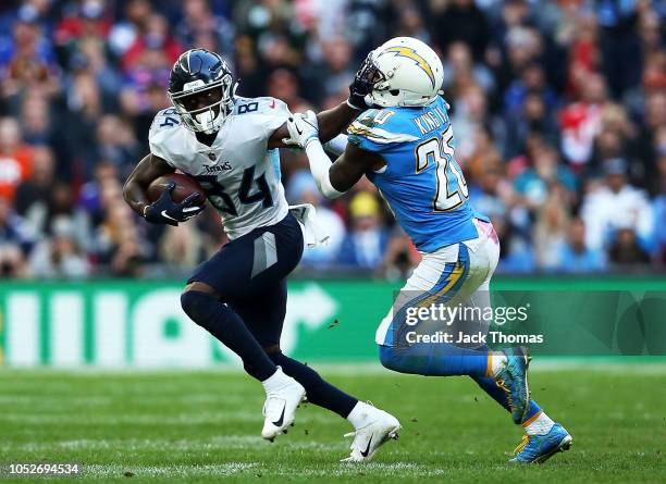 Corey Davis of the Tennessee Titans fends off Desmond King of the Los Angeles Chargers during the NFL International Series game between Tennessee...