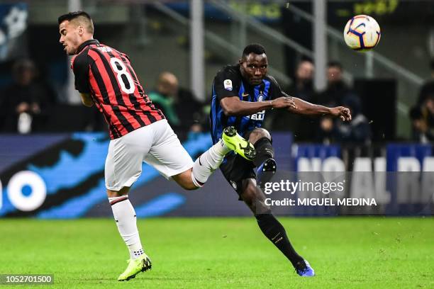 Inter Milan's Ghanaian midfielder Kwadwo Asamoah kicks the ball despite AC Milan's Spanish forward Suso during the Italian Serie A football match...