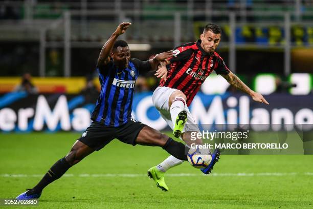 Inter Milan's Ghanaian midfielder Kwadwo Asamoah and AC Milan's Spanish forward Suso go for the ball during the Italian Serie A football match Inter...