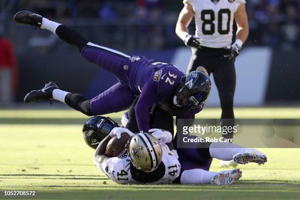 Running Back Alvin Kamara of the New Orleans Saints is tackled by linebacker C.J. Mosley and free safety Eric Weddle of the Baltimore Ravens in the...