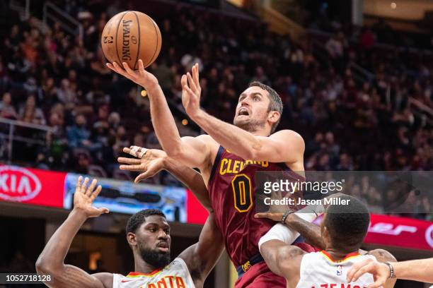 Kevin Love of the Cleveland Cavaliers shoots over Alex Poythress and Kent Bazemore of the Atlanta Hawks during the second half at Quicken Loans Arena...