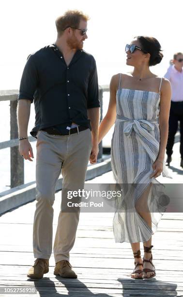 Meghan, Duchess of Sussex and Prince Harry, Duke of Sussex walk along Kingfisher Bay Jetty during a visit to Fraser Island on October 22, 2018 on...