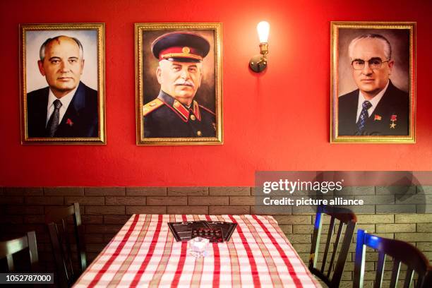 April 2018, Lower Saxony, Hanover: The portraits of former Soviet politicians Mikhail Gorbachev , Josef Stalin and Yuri Andropov hang in the KGB bar....