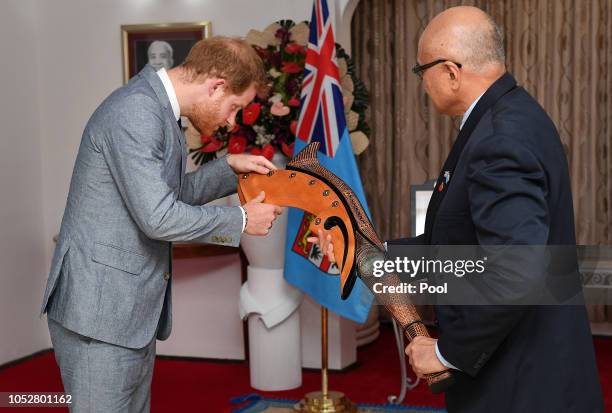 Prince Harry, Duke of Sussex receives a gift from the President of Fiji Jioji Konrote on the first day of their tour to Fiji on October 23, 2018 in...