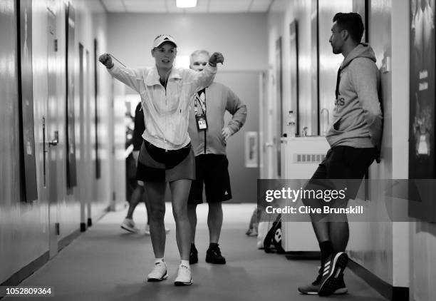 Caroline Wozniacki of Denmark warms up back stage with her coach Piortr Wozniacki during a prior to her singles match with Petra Kvitova of the Czech...