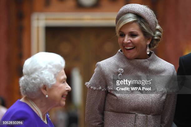 Queen Elizabeth II accompanies Queen Maxima of the Netherlands to view Dutch items from the Royal Collection at Buckingham Palace on October 23, 2018...