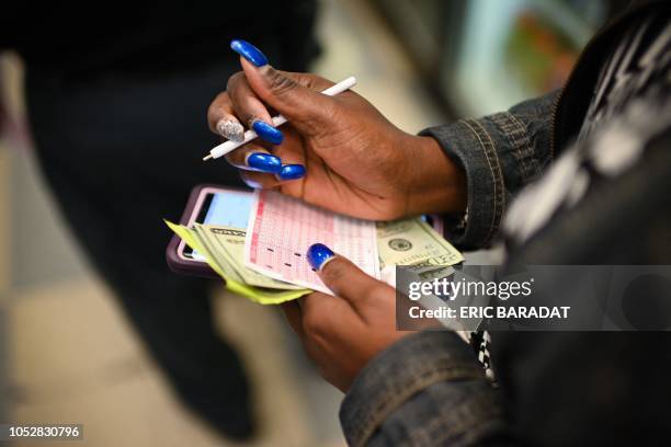 Woman buys Mega Millions tickets hours before the draw of the $1.6 billion jackpot, at a liquor store in Downtown Washington DC, on October 23, 2018....