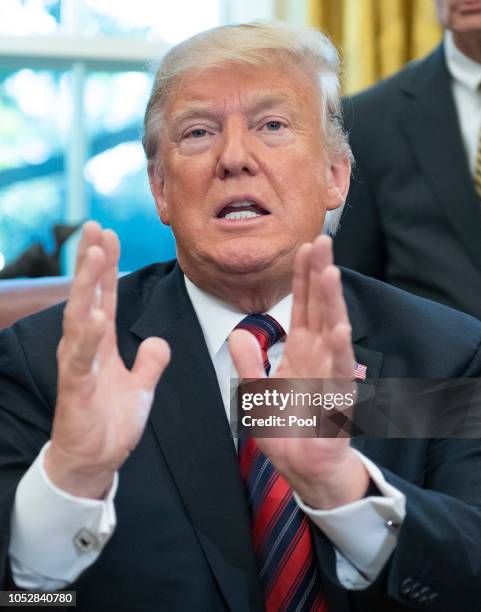 President Donald Trump speaks to the press pool after signing S.3021, America's Water Infrastructure Act of 2018, in the Oval Office of the White...