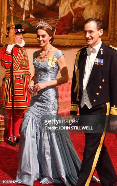 Britain's Catherine, Duchess of Cambridge, walks with Rear Admiral Ludger Brummelaar as they attend a State Banquet in honour of King...