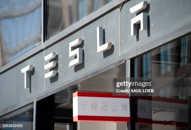 This file photo shows the Tesla logo is seen outside of their showroom in Washington, DC, on August 8, 2018. - Tesla shares surged on Tuesday October...