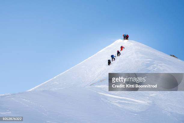 mountaineers climbing up to ascend the top of lenin peak, kyrgyzstan - snowy hill stock pictures, royalty-free photos & images