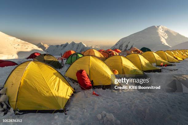 tents at camp 3 of lenin peak at sunrise, kyrgyzstan - base camp stock-fotos und bilder