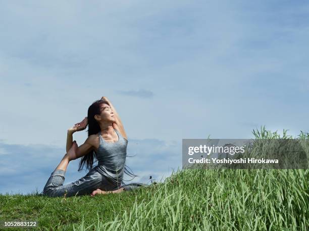 senior woman outdoors yoga coach - frau wiese bewegt stock-fotos und bilder