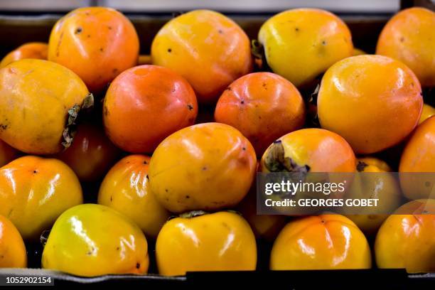 Persimmons are on sale in an organic supermarket in Saintes, western France, on October 23, 2018. - According to the public information platform...