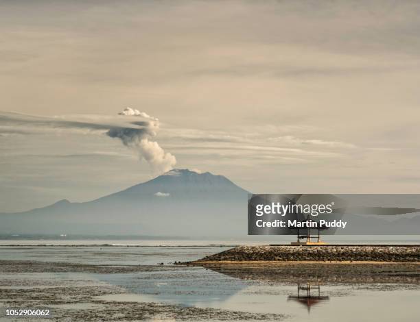 mount agung during eruption, from sanur beach, with balinese pavillion - sanur stock pictures, royalty-free photos & images