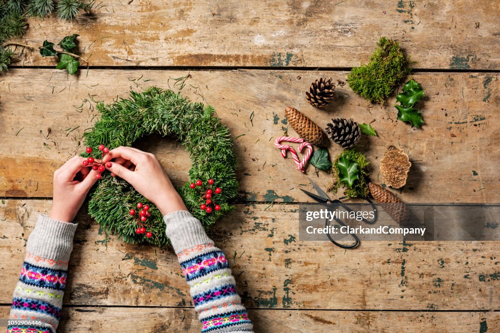 Overhead view of Christmas wreaths being made.