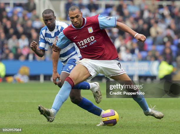 Kalife Cisse of Reading challenges John Carew of Aston Villa during the Barclays Premier League match between Reading and Aston Villa at the Madejski...