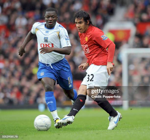 Carlos Tevez of Manchester United and Sulley Muntari of Portsmouth in action during the FA Cup Sponsored by E.on Quarter Final match between...