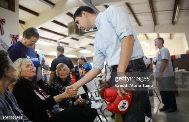 Democratic congressional candidate Josh Harder greets a supporter, as he holds a pair of boxing gloves given to him as a gift, at a campaign rally in...