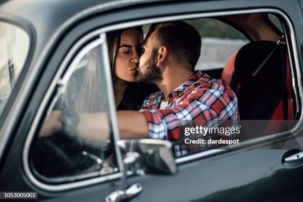 paar küssen den sonnenuntergang in einem auto. - auto küssen stock-fotos und bilder