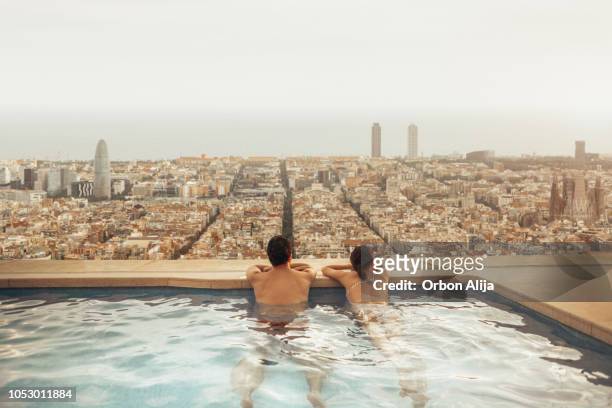 paar auf hoteldach blick auf skyline von barcelona. fotomontage. - barcelona spanien stock-fotos und bilder