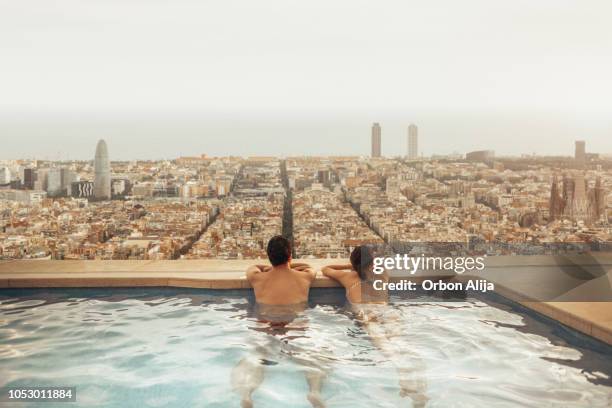 couple relaxing on hotel rooftop looking at barcelona city skyline. photo composition. - hotel imagens e fotografias de stock
