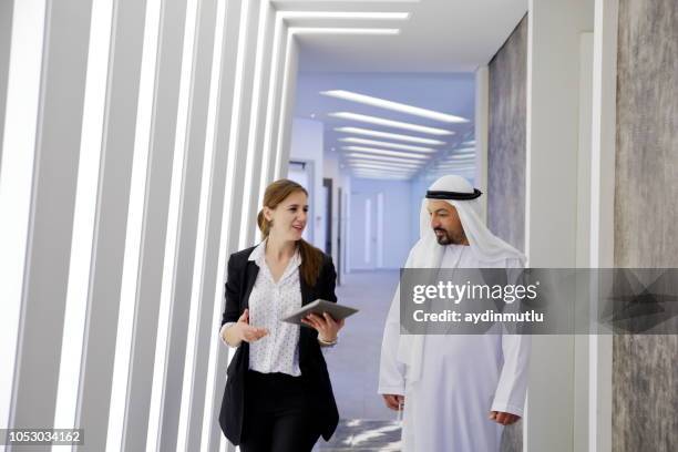 arab businessman and cooperation woman - abu dhabi business stock pictures, royalty-free photos & images