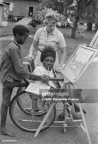 Mary Wanda, une jeune fille-tronc peint avec la bouche, un jeune unijambiste derrière elle, au centre de handicapés physiques de la Croix-Rouge au...