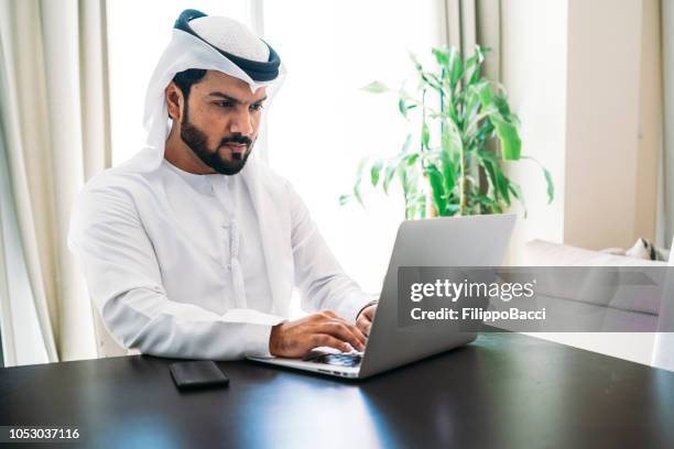arab man working with laptop - middle eastern culture stock pictures, royalty-free photos & images