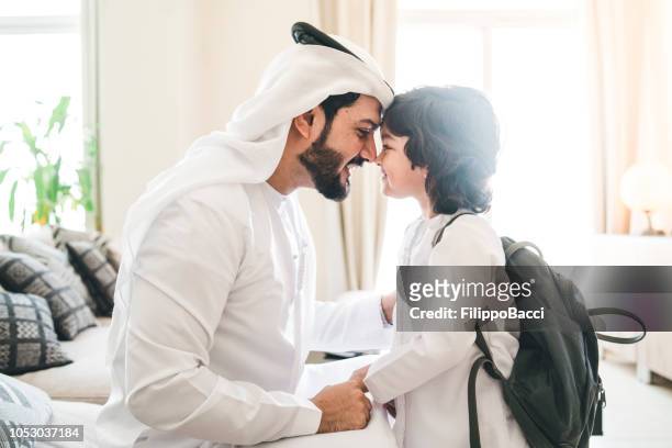 back to school time: arab dad saying hello to his son - arab family stock pictures, royalty-free photos & images