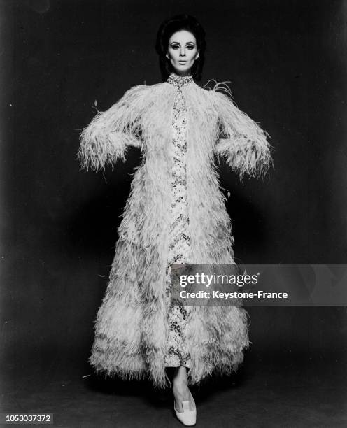 Ensemble de gala composé d'une robe brodée de paillettes et de pierreries et d'un manteau d'autruche création Jean Patou, à Paris, France, en août...